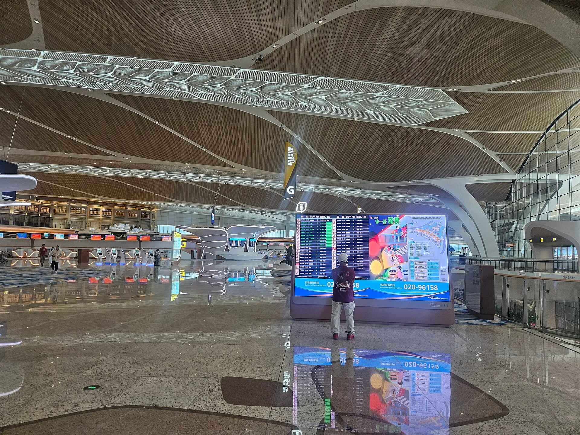 Departures hall of Baiyun Airport Terminal 3 with the flight board and check-in island G behind it