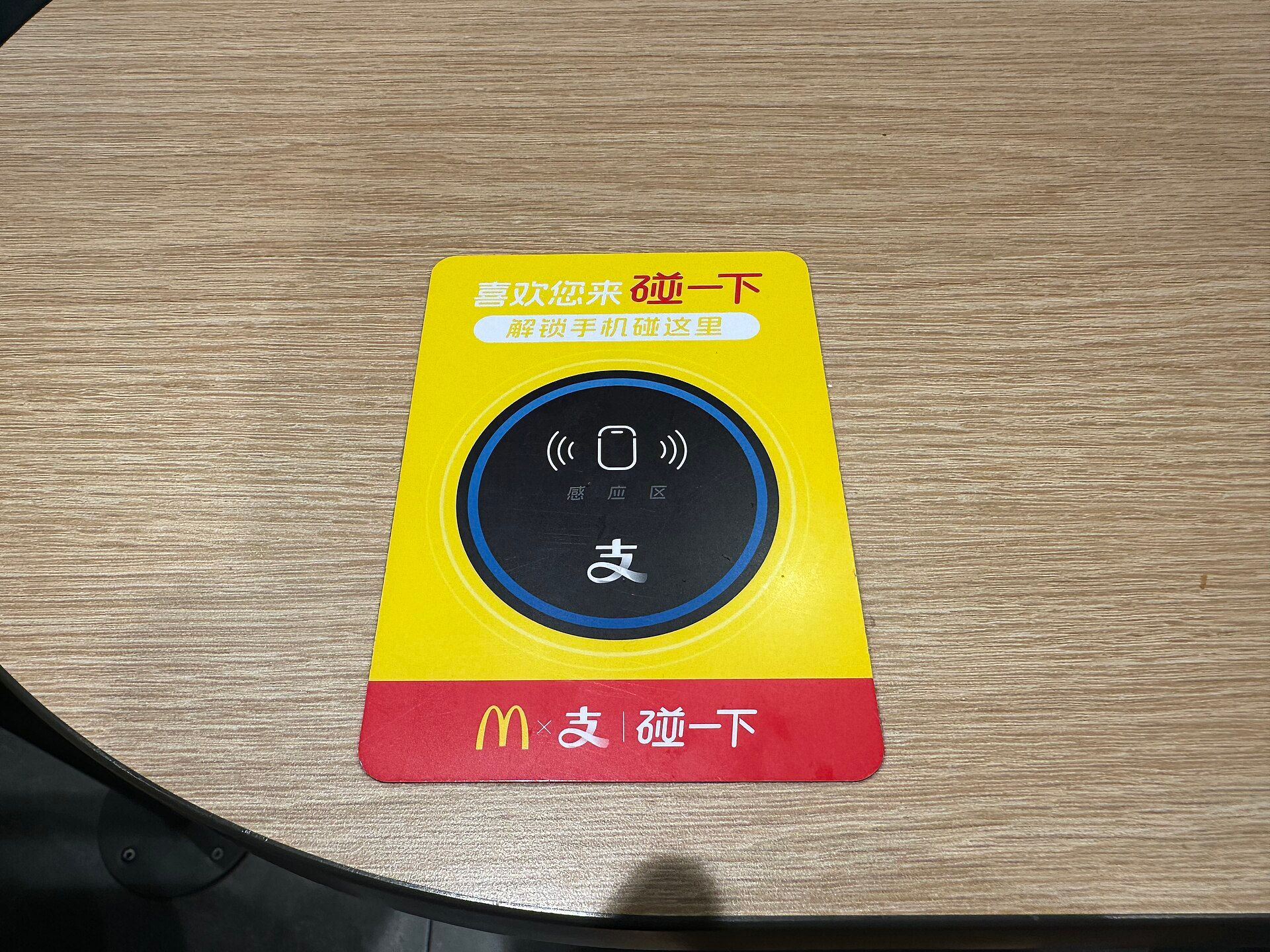 Alipay tap-to-pay sensor sticker on a restaurant table in China