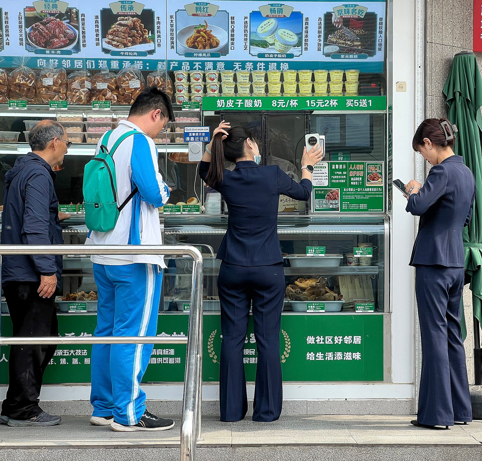 Customers paying by phone at a food shop counter, Beijing