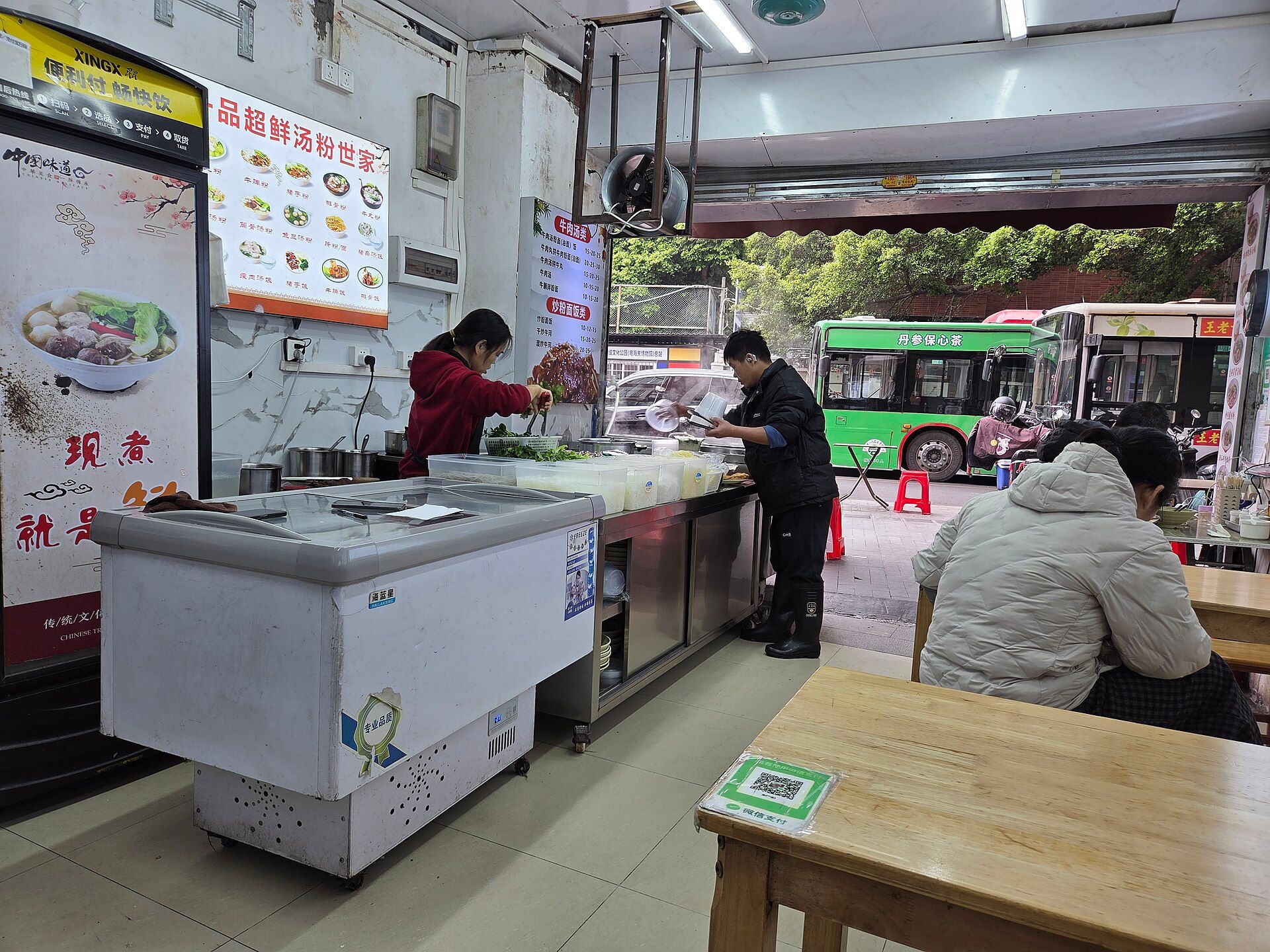 Neighbourhood noodle shop with a WeChat Pay code on the table, Guangzhou