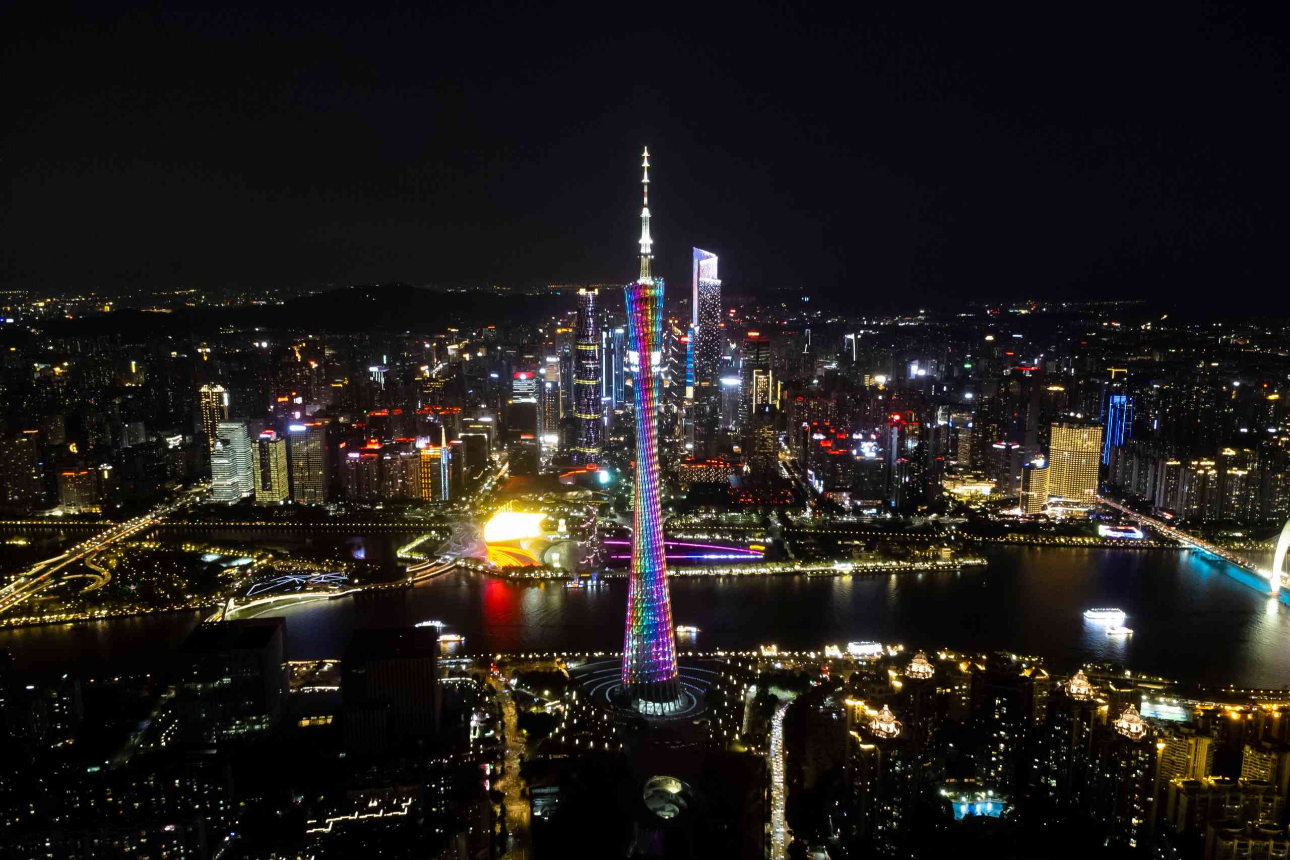 Canton Tower lit up at night above the Pearl River and the city skyline