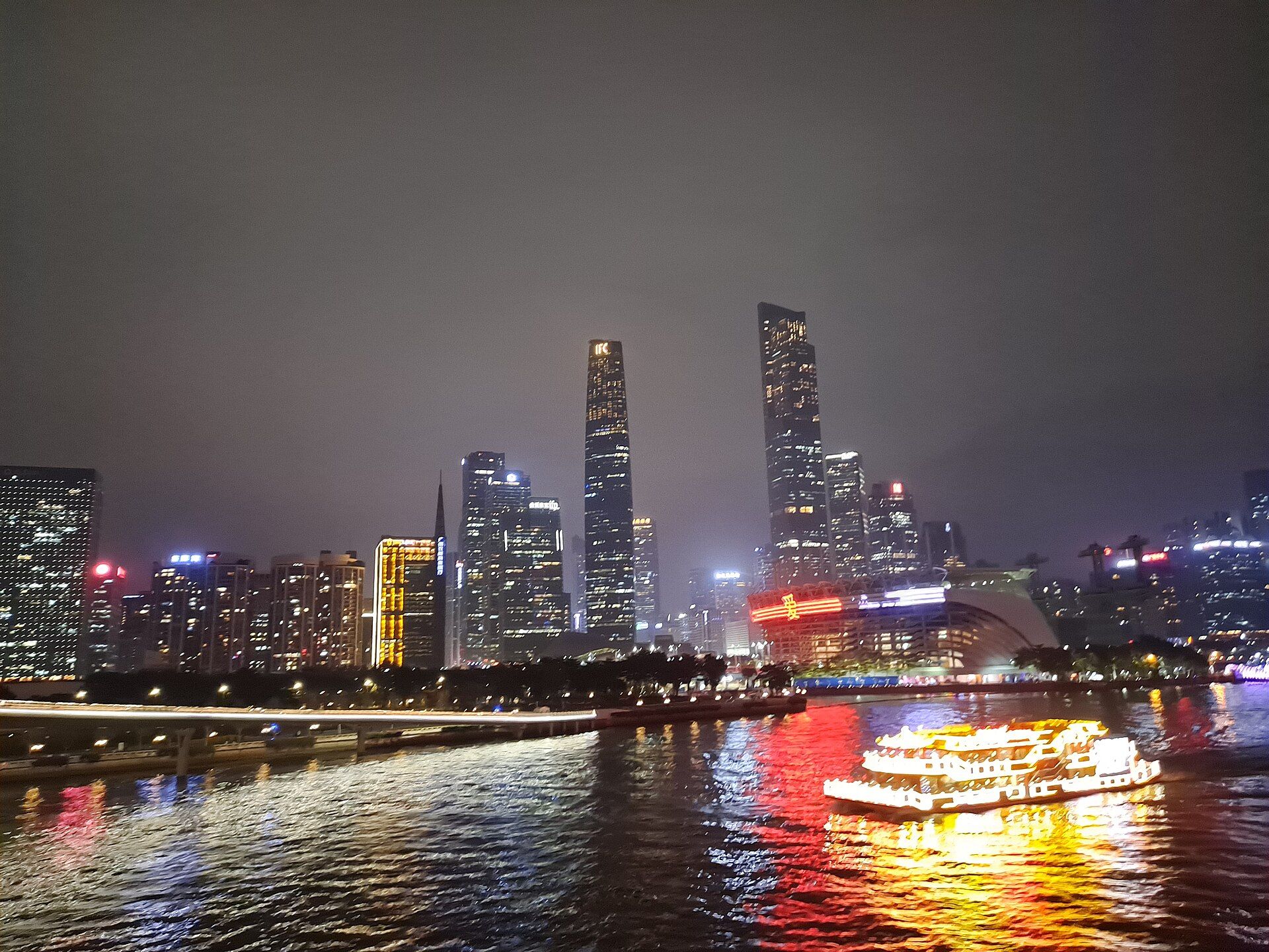 Pearl River night cruise boat passing Zhujiang New Town